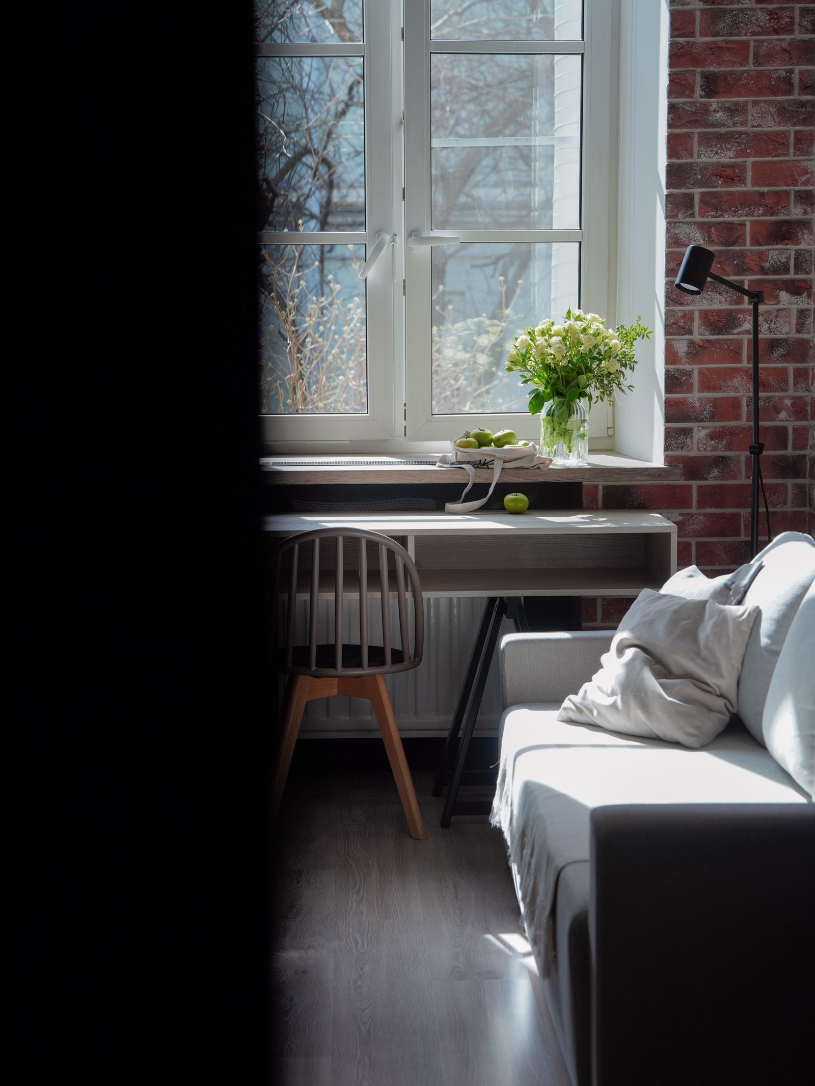 Sunlit desk beside a brick wall and flowers
